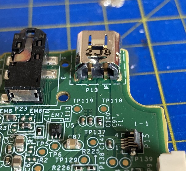 Photo of the Wii U gamepad motherboard, zoomed in on the original charging port. The port superficially resembles a Mini USB socket, but with only two metal contacts reaching the PCB.